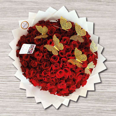 Heart-shaped bouquet of red roses with gold butterfly picks