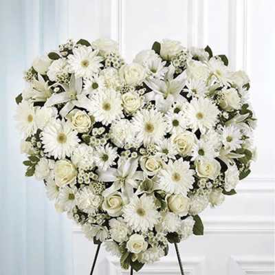 Heart-shaped white floral standing spray on an easel