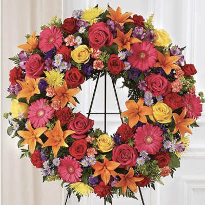 Colorful floral wreath on a black easel stand