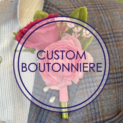 Pink floral boutonniere with pearl pins on a blue plaid suit jacket