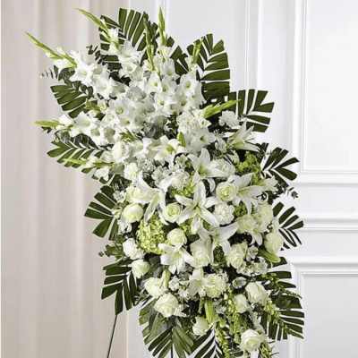 White floral standing spray with lilies and roses on a display easel