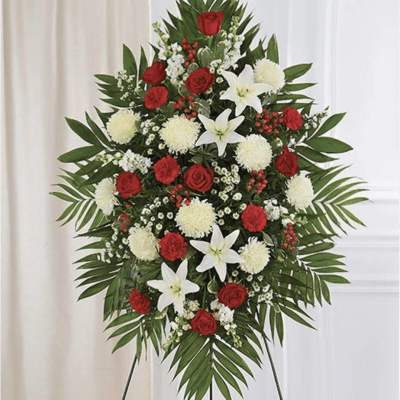 Standing floral spray with red roses, white lilies, and white pompons