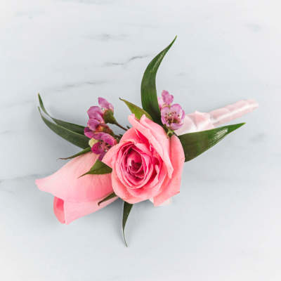 Pink rose boutonniere with small purple flowers and ribbon wrap
