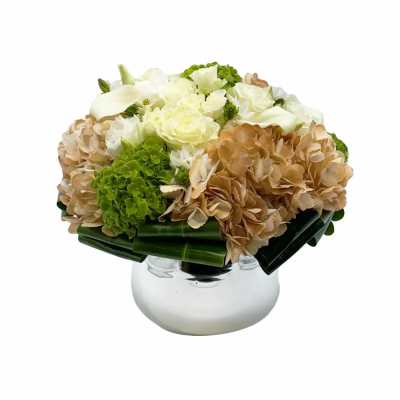 White and tan floral arrangement in a clear glass vase