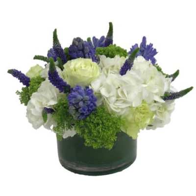 White and purple floral arrangement in a dark round vase