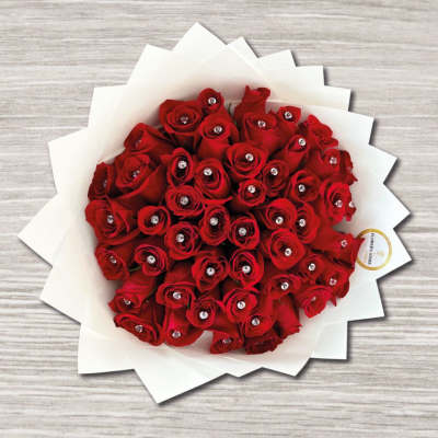 Bouquet of red roses wrapped in white paper