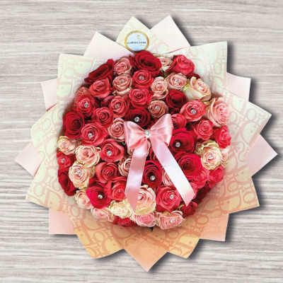 Round bouquet of red and pink roses with a satin bow