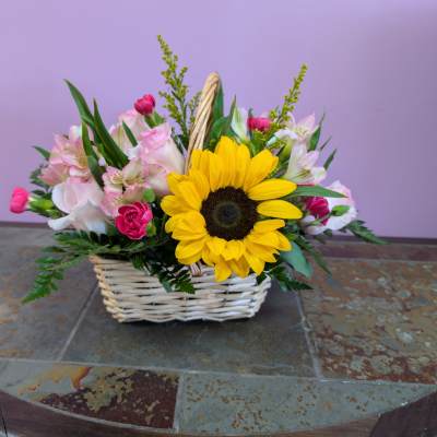 Basket arrangement with a sunflower and pink mixed flowers