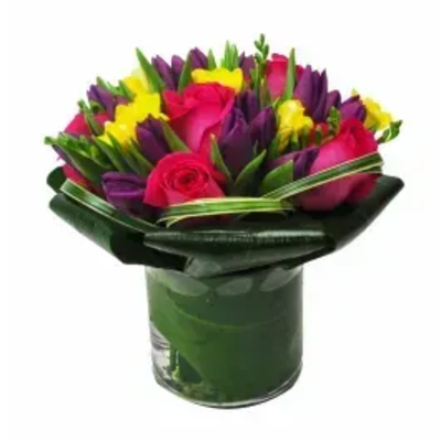 Bouquet of pink roses, purple tulips, and yellow flowers in a glass vase