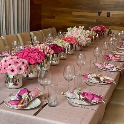 Long banquet table with pink floral centerpieces and place settings