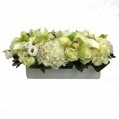 White and pale green floral arrangement in a rectangular box