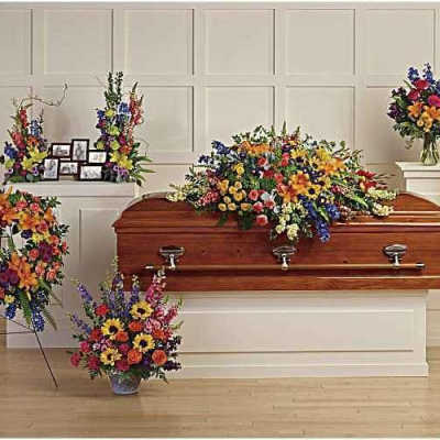 Casket surrounded by colorful funeral flower arrangements