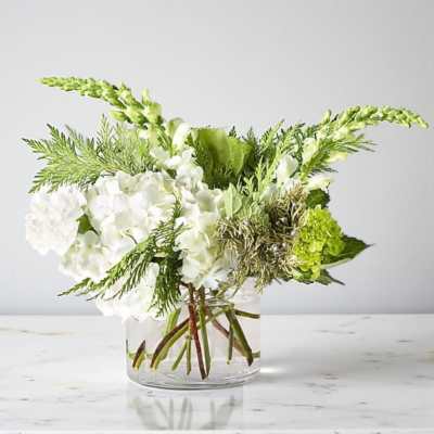 White and green floral arrangement in a clear glass vase