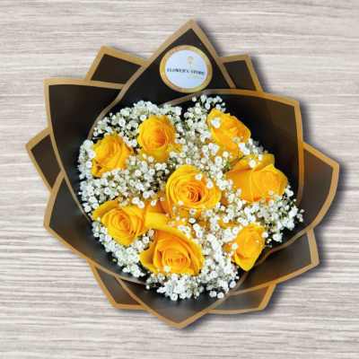 Bouquet of yellow roses with white baby's breath in dark wrap