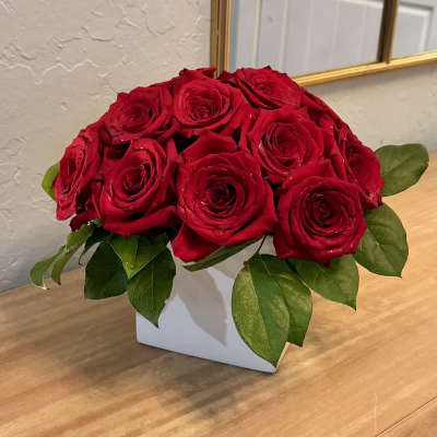 Red roses arranged in a white square vase