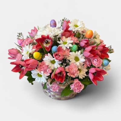 Pink tulips, white daisies, and carnations in a basket with colorful Easter eggs.