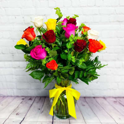 Mixed roses in a glass vase with a yellow ribbon