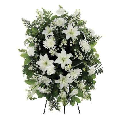 White funeral spray with lilies and chrysanthemums on a stand
