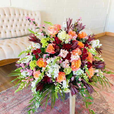 Large floral arrangement with pink, orange, white, and burgundy blooms