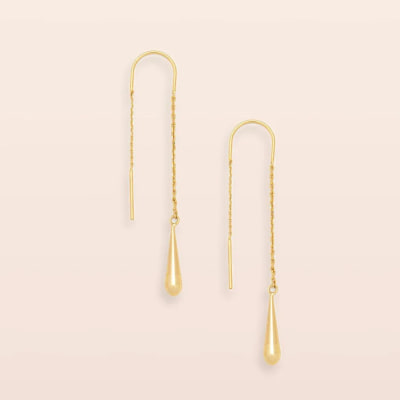 Pair of gold threader earrings with teardrop dangles on a light background