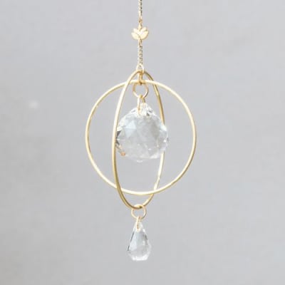 Gold hanging ornament with faceted clear crystal sphere and teardrop on a delicate chain