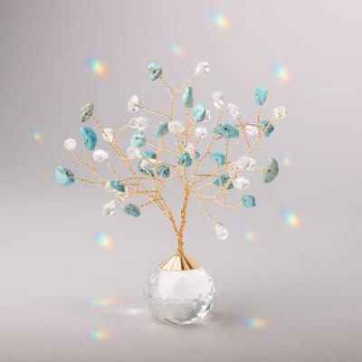 Decorative gold wire tree with turquoise and clear crystals in a faceted glass base