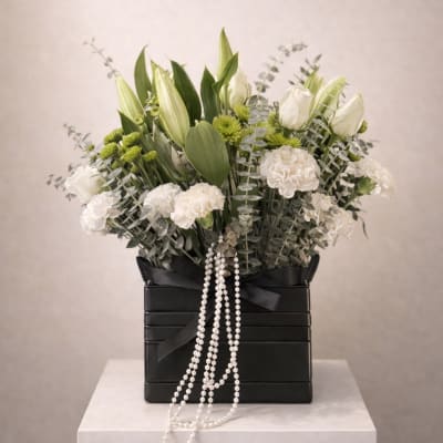White lilies, roses, carnations and green mums in a black box with pearl strands