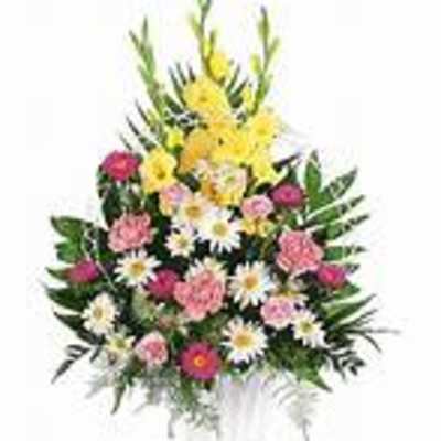 Mixed pink and yellow flower arrangement in a clear vase