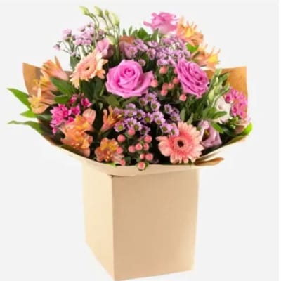 Mixed pink and peach flower bouquet in a tan box