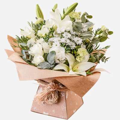 White floral bouquet in brown paper wrap with a decorative box base