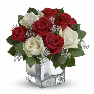 Red and white roses in a clear square vase