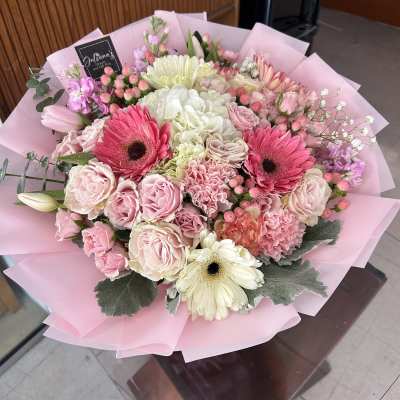 Pink and white mixed bouquet with gerbera daisies and roses wrapped in pink paper