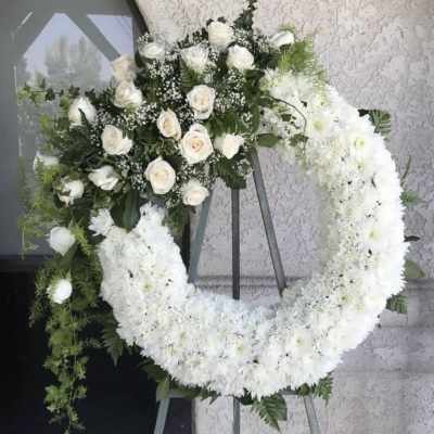 White rose and chrysanthemum funeral wreath on an easel