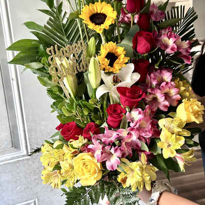 Tall bouquet of red roses, white lilies, and yellow sunflowers