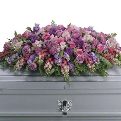 Pink and purple floral casket spray with roses and mixed blooms