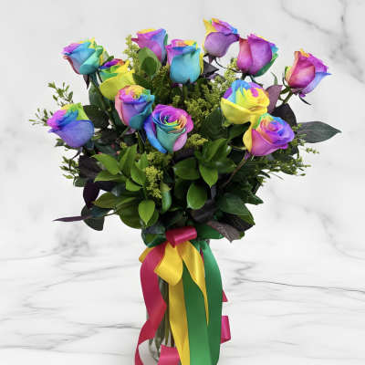 Bouquet of rainbow-colored roses in a glass vase with multicolor ribbons