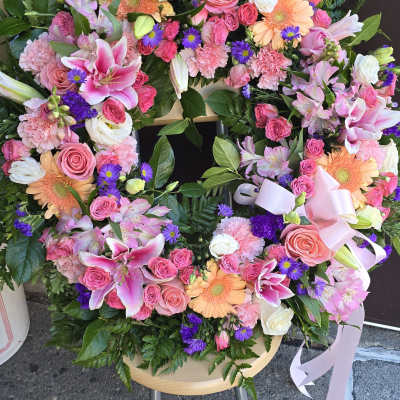 Heart-shaped floral wreath with pink and peach blooms and purple accents