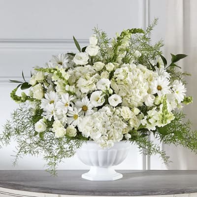 White floral arrangement in a white pedestal vase