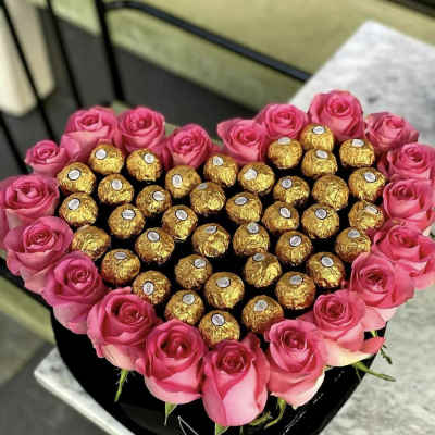 Heart-shaped box of pink roses filled with gold-wrapped chocolates