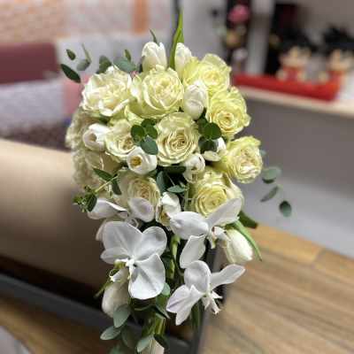 Cascade bouquet of pale yellow roses and white orchids
