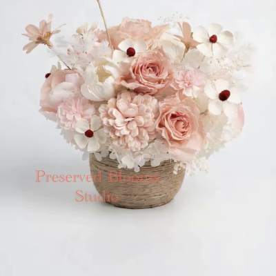 Pastel peach and white flower arrangement in a woven basket