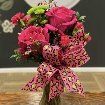 Pink rose bouquet in a glass vase with a leopard-print ribbon