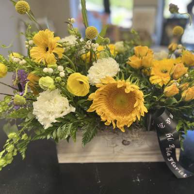 Yellow and white mixed flower arrangement in a wooden box