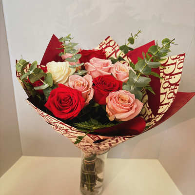 Bouquet of red, pink, and white roses in a glass vase