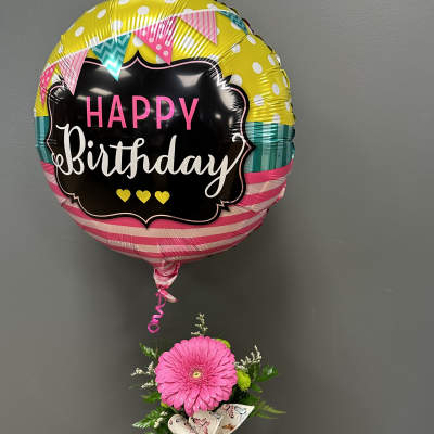 Birthday balloon above a pink gerbera in a glass vase