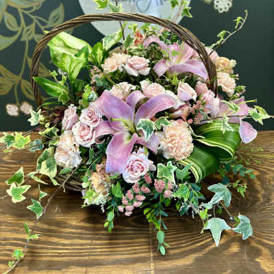 Basket arrangement with pink lilies, roses, and carnations