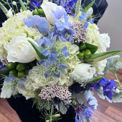 Bouquet of white and blue flowers with green accents