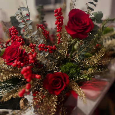 Red roses with red berry stems and mixed greenery