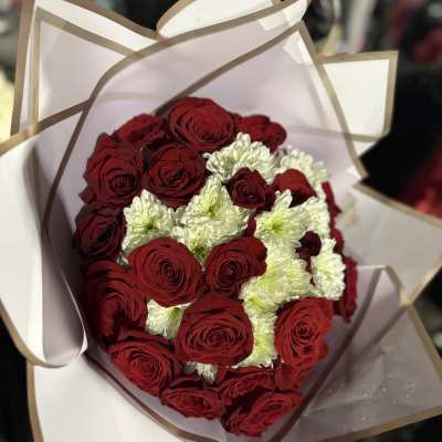 Bouquet of red roses and white chrysanthemums wrapped in white paper