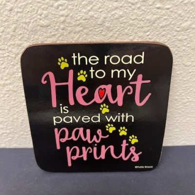 Black sign with pink text and yellow paw prints